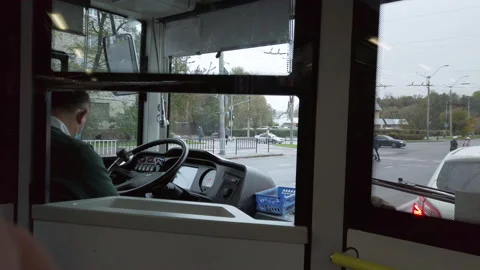 View on bus driver cabin riding bus. Driver wearing protective face mask  Video stock 141983873