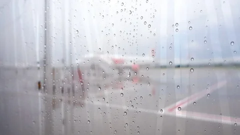 View from bus. Raindrops on window glass with plane in airport background. Stock Footage 70016140