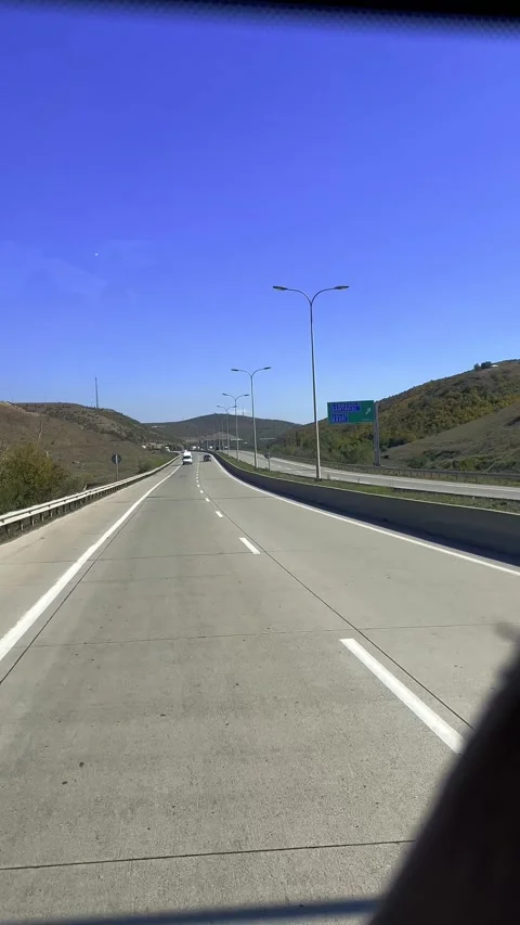 View from bus window of mountain, highway, track, tree, grass, car Stock Footage 290152595