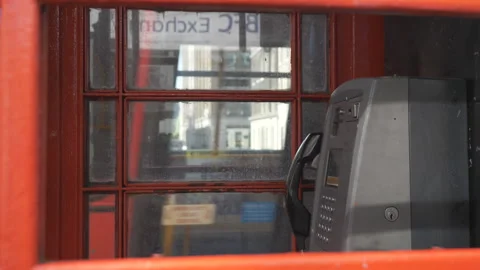 A view of a busy road through a red telephone booth. Stock Footage 114011470