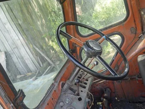 View of the cab of an old tractor. Steering wheel and interior of the cab. Ag Stock Photos