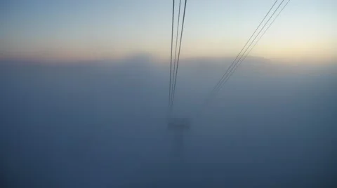 View from a cabin to a cable car tower appearing from the fog. Low visibility at Stockbeeldmateriaal 65530636
