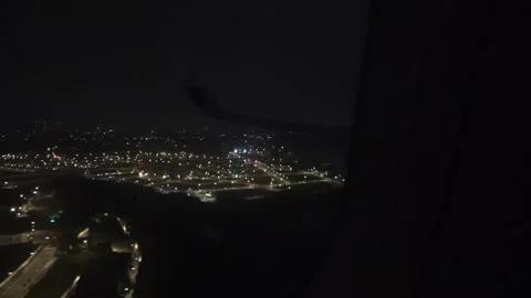 View from the cabin: one plane descending into the urban night. Stock Footage 332619912