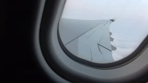 View from the cabin: one plane piercing through a single cloud layer. Stock Footage 332617951