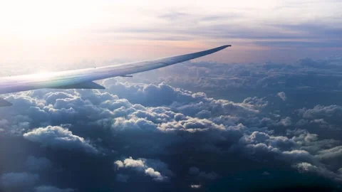 View from the cabin window on the plane wing flying among the clouds on sunset Stock Footage 201272026