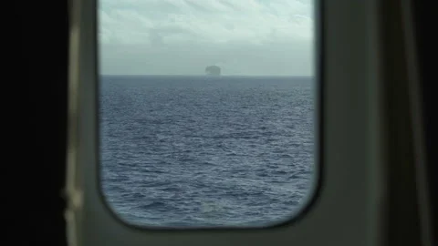 View from cabin window: sea and ship. Pitching. Large ship sails away into the Stock Footage 168994850