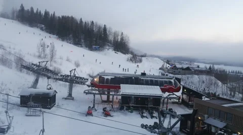A view from cable car cabin on ski resort and ski path with skiing people Видео 64921694