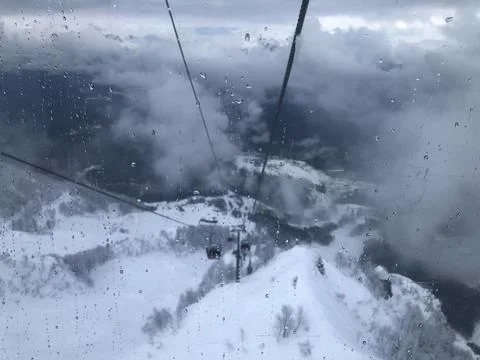 The view from the cable car down to the snowy mountains Stock Photos