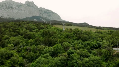 View on the cable car with a rising funicular, mountains and green forest Stock Footage 170379433