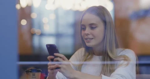 View in cafe window of beautiful cheerful caucasian young woman texting message Stock Footage 143736687