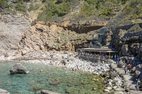 View on Cala de Deia, tiny rocky beach and a restaurant in Mallorca, Balear.. Stock Photos