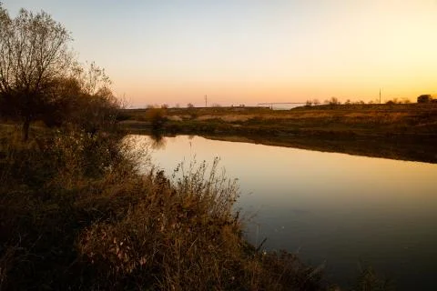 View of a calm river with sunset light Stock Photos