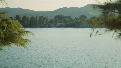 A view of calm scenic lake, surrounded by mountains and hills. Summer evening Stock Footage 285807523