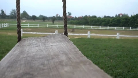 View of camera on empty swing swaying at garden Stock Footage 69237050