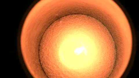 View of a candle's flame flickering gently amidst a warm, glowing interior Stock Footage 326968931