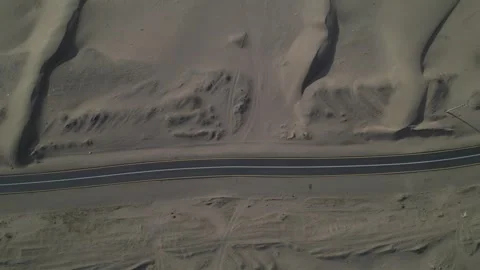 View of a car driving over a road in the middle of the desert Stock Footage 263277550