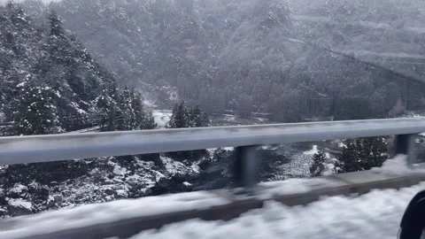 View from a car driving through snowy terrain on a mountain highway in winter. Stock Footage 304846248