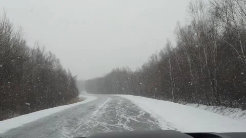 View from car to heavy snowfall on road in Russia slow motion video Stock-Footage 146100198