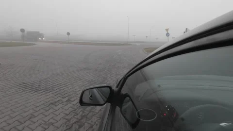 View from a car-mounted camera driving through foggy conditions, showing pa.. Stock Footage 295764466