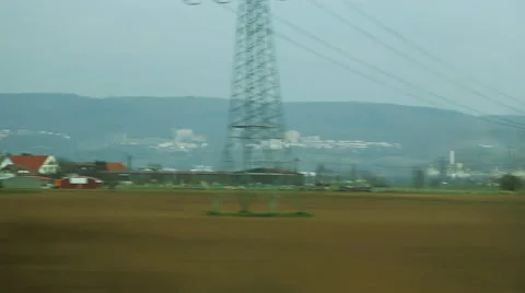 View from a car. Parallel driving along green farmlands and high voltage cables. Stock Footage 68027846