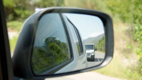View from car in rearview mirror, minivan is driving behind one car. need to Stock-Footage 218275101