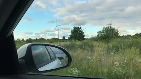 View from car to spinning wind turbines Stock Footage 202082676