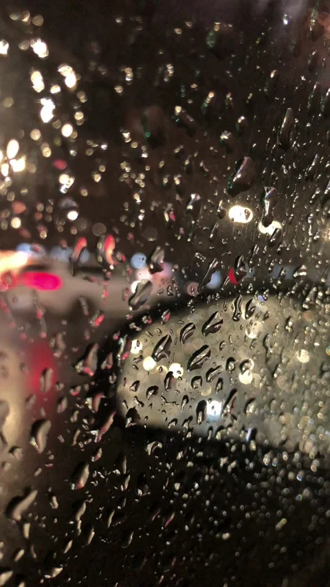 A view from a car through a glass with raindrops of the night city Stock-Footage 318359664