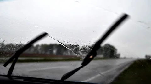 View from the car through windshield with drops of water wipers cleaning glass. Stock Footage 130918970