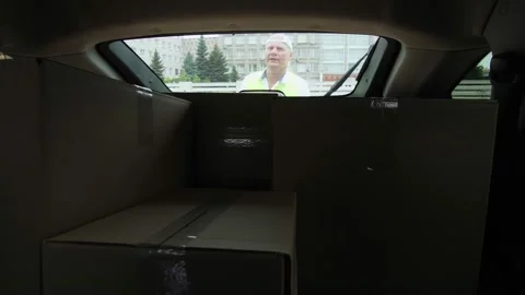 View from car trunk: Couriers, man and woman, unloading parcels, cardboard boxes 스톡 동영상 133289519