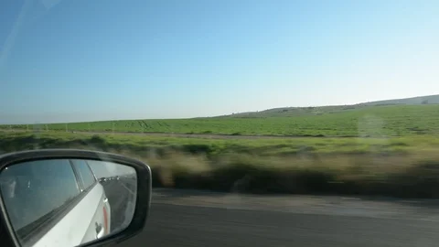 View from car window on green hills and blue sky. Growing wheat fields. Stock Footage 102000396