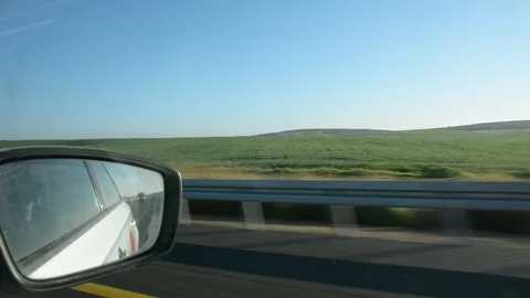 View from car window on green hills and blue sky. Growing wheat fields. Stock Footage 102000433