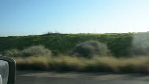 View from car window on green hills and blue sky. Growing wheat fields. Vídeos de archivo 102001903