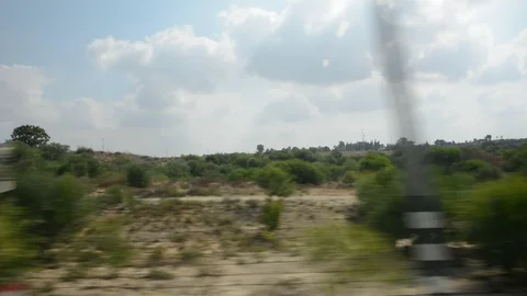 View from car window on green hills and blue sky. Growing wheat fields. Видео 115665217