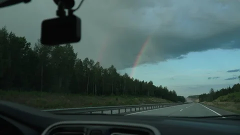 View from car window onto highway and rainbow, handheld shot. Stock Footage 252984196