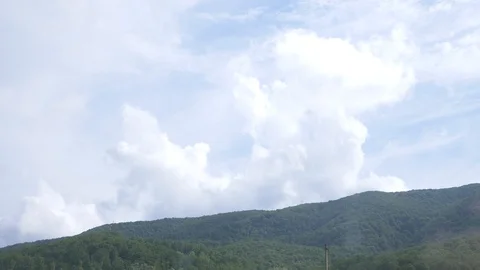 View from the car window on a mountainous landscape, cumulus clouds and trees in Stock-Footage 90016901
