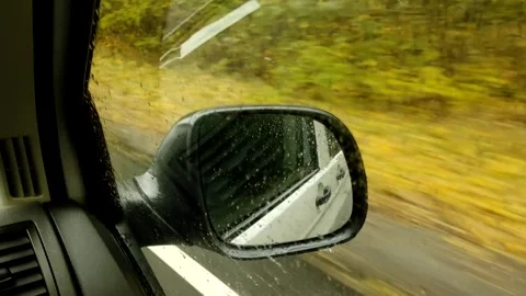 The view from the car window on the rear view mirror on a rainy autumn day. Stock Footage 154614255