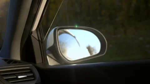 View from the car window to the rearview mirror while driving, which reflects Видео 119581005
