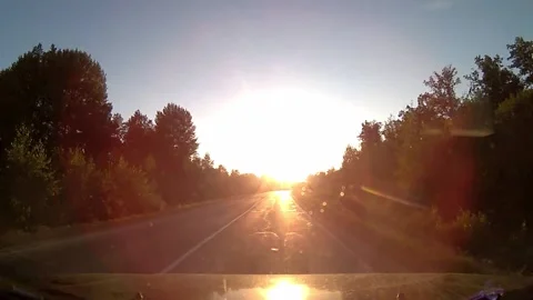 View from the car window on the road in the evening at sunset, bright sun gla Stock Footage 172361814