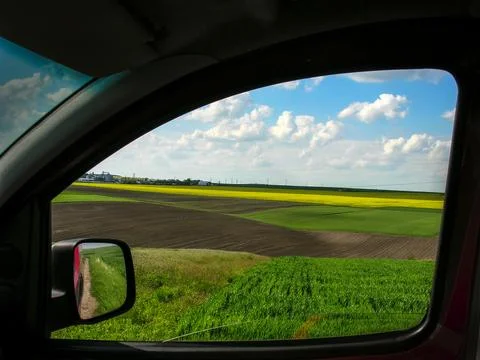 View from car window on waves and hills of Agricultural fields Stock Photos