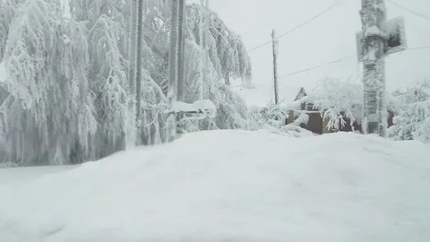 View from the car window while driving on a snow-covered street and heavily Stock Footage 123892337