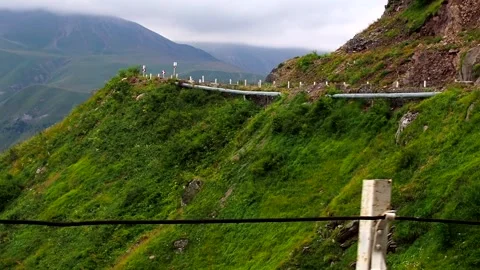 The view from the car window of the winding mountain road and mountain ranges Stock Footage 248528767