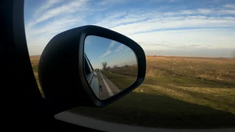 View of car wing mirror while driving through countryside landscape Video stock 148440147