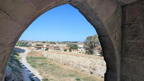 View of Carcassonne lower town through a stone arch of the medieval ramparts Stock Photos