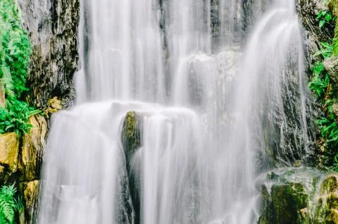 View of cascading water falling over the rocks at Longshan temple in Taipei Stock Photos