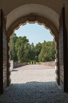View on a castle grounds bridge through a entrance gate. Stock Photos