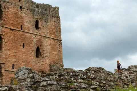 View of a castle tower with the stone wall and a child on walking on Stock Photos