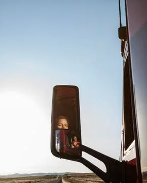 View of a Caucasian woman driver in the cab of her  commercial truck. Stock Photos