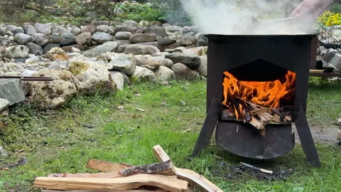 View of a cauldron over an open fire outdoors, cooking pilaf Stock Footage 308777759