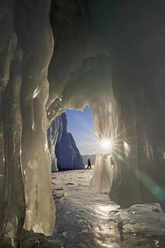 View from a cave covered with ice on a walking man Foto stock