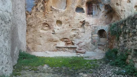 View of a cave house wall with a drone Stock Footage 126899643